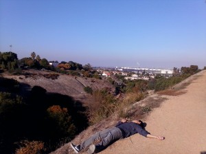 A young college man's body is sprawled out on a hillside