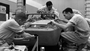 black-and-white photo of 3 designers carving a body shape for an early prototype for the Ford Mustang