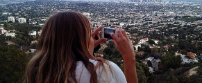 Photo of Ida Bohlin on the balcony at the Griffith Park Observatory taking a cell phone photo of the Los Angeles skyline