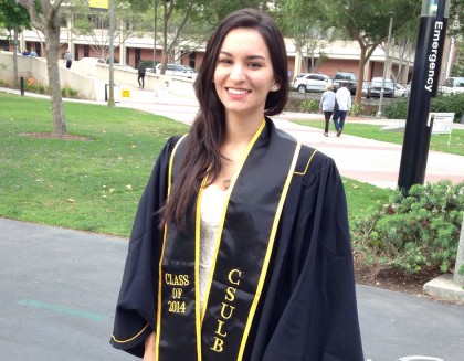 a woman in a graduation robe with a banner reading "CSULB Class of 2014"