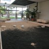 Photo of Glenn Zucman's "Zen Entropy Garden" (a large "zen garden" / sandbox with half white sand, and half black sand, and rakes that let visitors create their own zen garden configurations as they also mix the sand into an entropic grey) installed in the CSULB School of Art, Art Gallery Courtyard