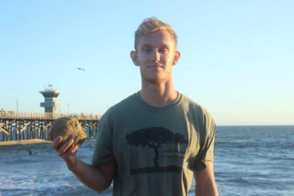 Connor Bailey at the beach showing his plaster casting of his hand