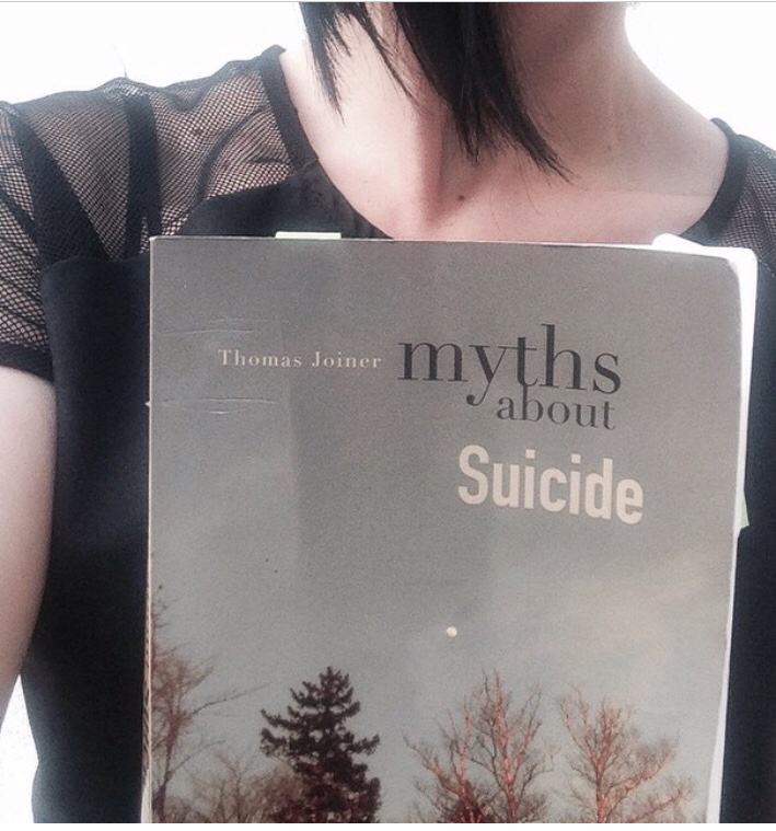 photo of Merry Death from the neck down and holding a book in front of her