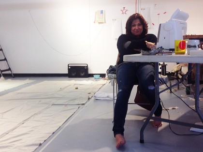 Pilar Elizabeth sits in a chair surrounded by cotton flag making materials in the CSULB School of Art (SOA) Dutzi Gallery on Tuesday 27 January 2015