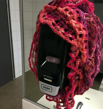 photo of knitting surrounding the soap dispenser in a bathroom at the Los Cerritos dorm