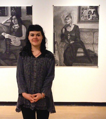 Emily Babette stands in front of large-scale charcoal drawings in the CSULB School of Art's Gatov Gallery in Long Beach, California. Photo by Valerie Arredondo