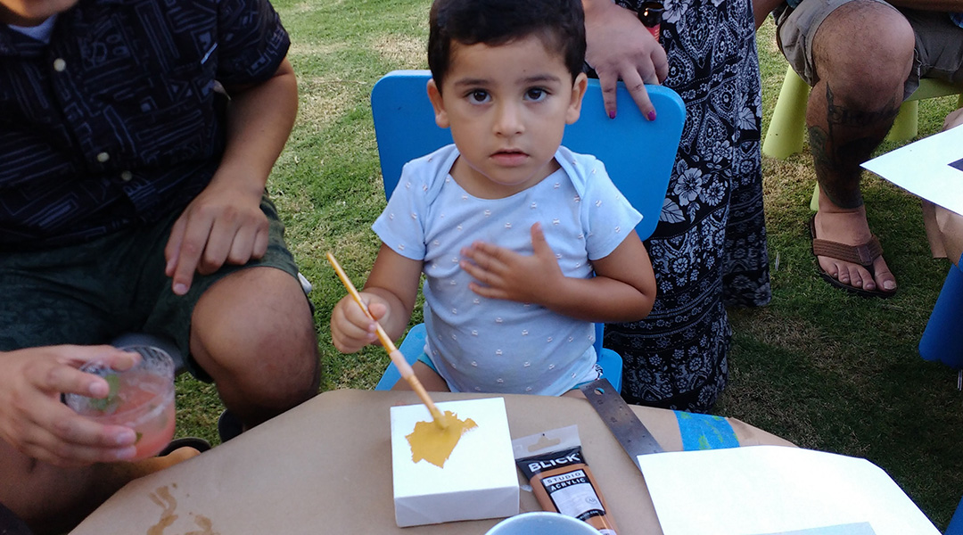 photo of a child painting on a small canvas